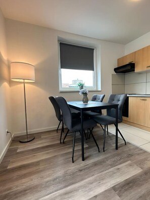 Cocina compacta con zona de comedor, una lámpara de pie y ventana con vistas.