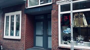 A two-story building with a brick facade, a black awning over the entrance, and a sign reading "Ochsenstraße".