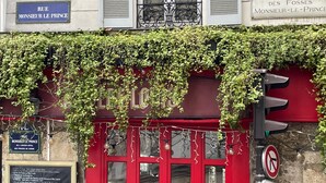 A building facade with a red door and a sign reading "RUE MONSIEUR LE PRINCE".