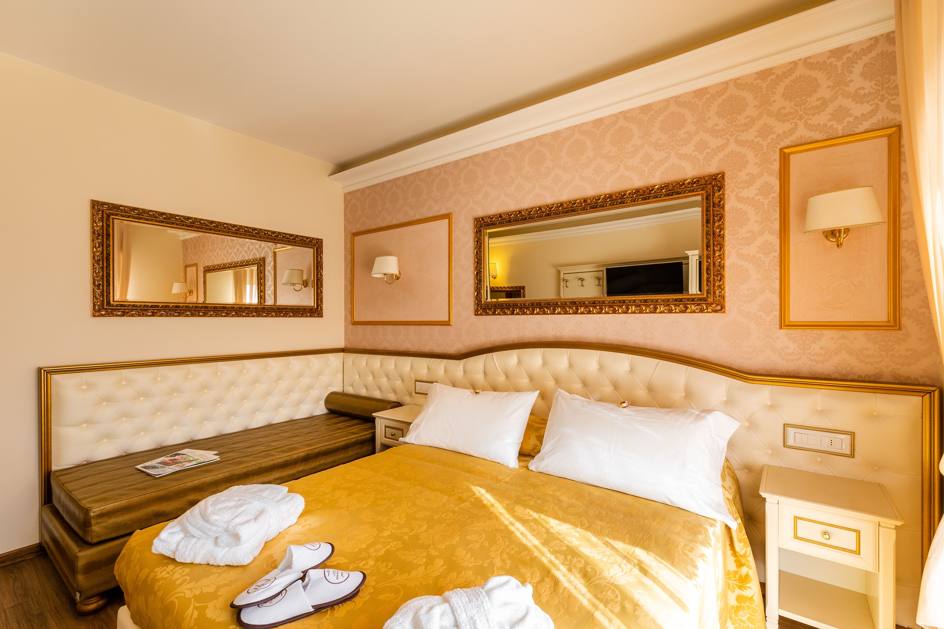 Una camera d'albergo con un letto grande, un comodino e uno specchio a parete.