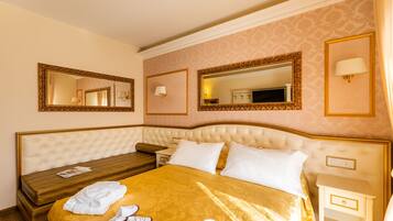 Una camera d'albergo con un letto grande, un comodino e uno specchio a parete.