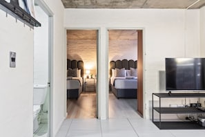 A modern hotel room with a large bed, a TV, and a small desk. - The Hub 602 (Cape Town)