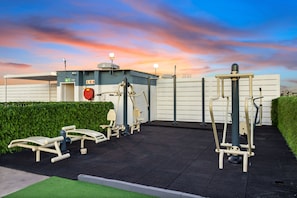 Outdoor exercise equipment, a covered area, and a building with a sign. - The Hub 602 (Cape Town)