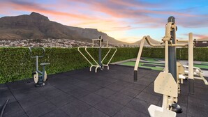 Outdoor exercise equipment with a cityscape and mountains in the background. - The Hub 602 (Cape Town)