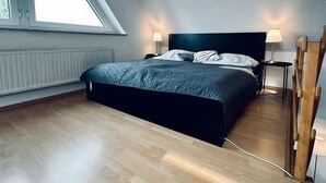 Ein modernes Schlafzimmer mit einem großen Bett, einem Oberlicht und einer Heizkörper.