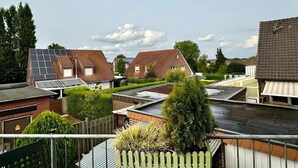 Ein Wohngebiet mit Häusern, Solaranlagen und einem Holzzaun.