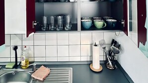 Eine Küche mit offenen Schränken, die verschiedene Geschirrteile und Gläser zeigen.