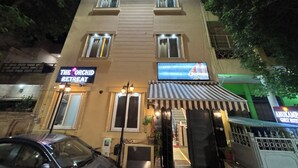 A building with multiple windows, a sign for 'The Orchid Retreat', and a visible entrance with a gate. - The Orchid Retreat Agra - Stay Near Taj Mahal (Agra)