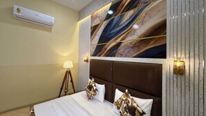 A hotel room with a large bed, a marble-patterned headboard, a standing lamp, and an air conditioning unit. - The Orchid Retreat Agra - Stay Near Taj Mahal (Agra)