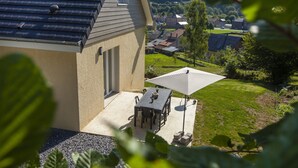 A house with a patio, a table, and an umbrella.