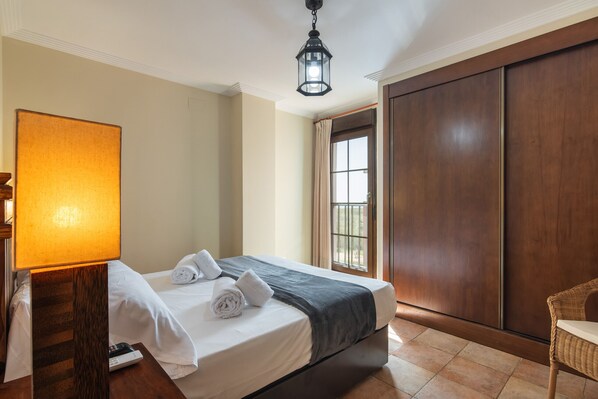 A hotel room with a bed, a lamp, a wardrobe, and a window. - Las Palmeras - Punta del Moral Beach PLHP51P65 (Punta del Moral)