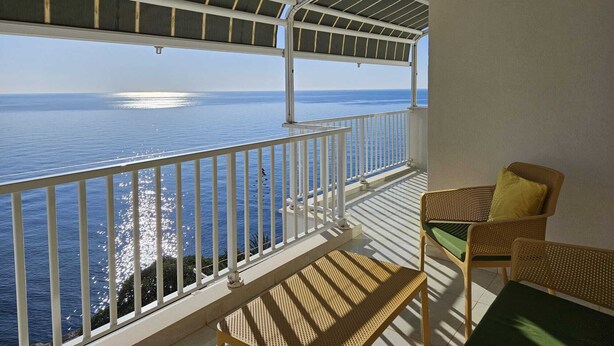 A balcony with a view of the sea, white railings, and wicker furniture. - Mario` place - penthouse with sea view terrace (Dubrovnik)