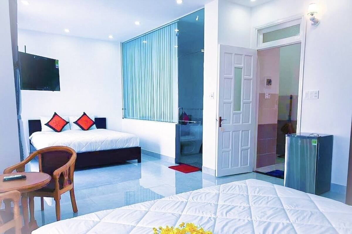 A hotel room with a bed, a chair, a TV, and a wardrobe.