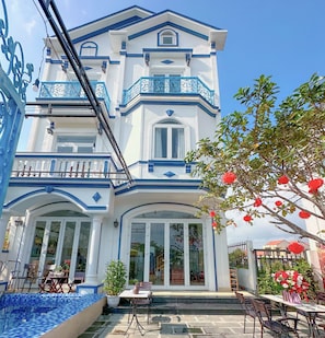 A two-story building with a balcony, large windows, and a pool area. - Blue Fish Villa (Da Nang)