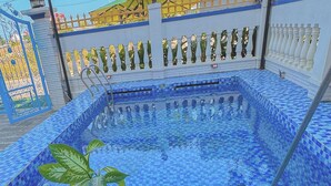 A swimming pool with blue mosaic tiles, surrounded by a white fence with decorative elements. - Blue Fish Villa (Da Nang)