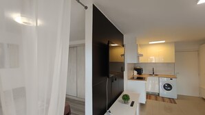 Eine moderne Küche mit einer eingebauten Waschmaschine, einer kleinen Arbeitsplatte und einem Blumentopf.