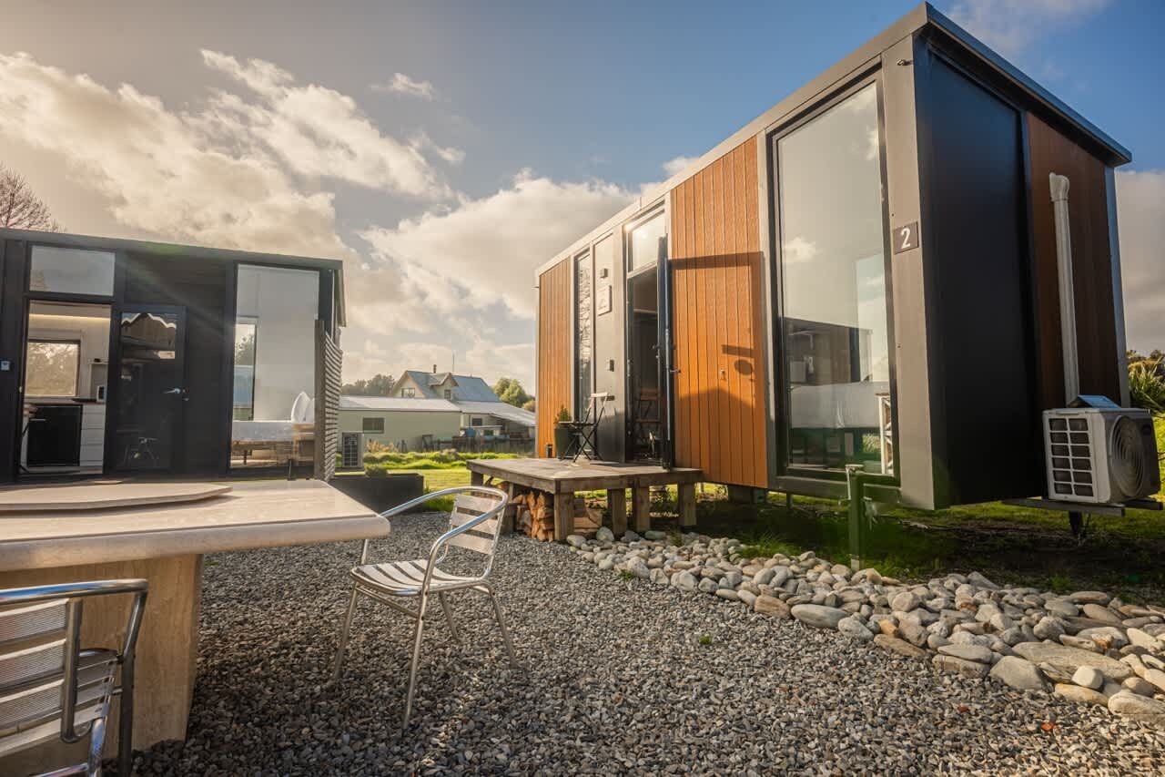 Un espace cuisine extérieur moderne, doté d’un barbecue, de sièges et offrant une vue sur le paysage environnant.