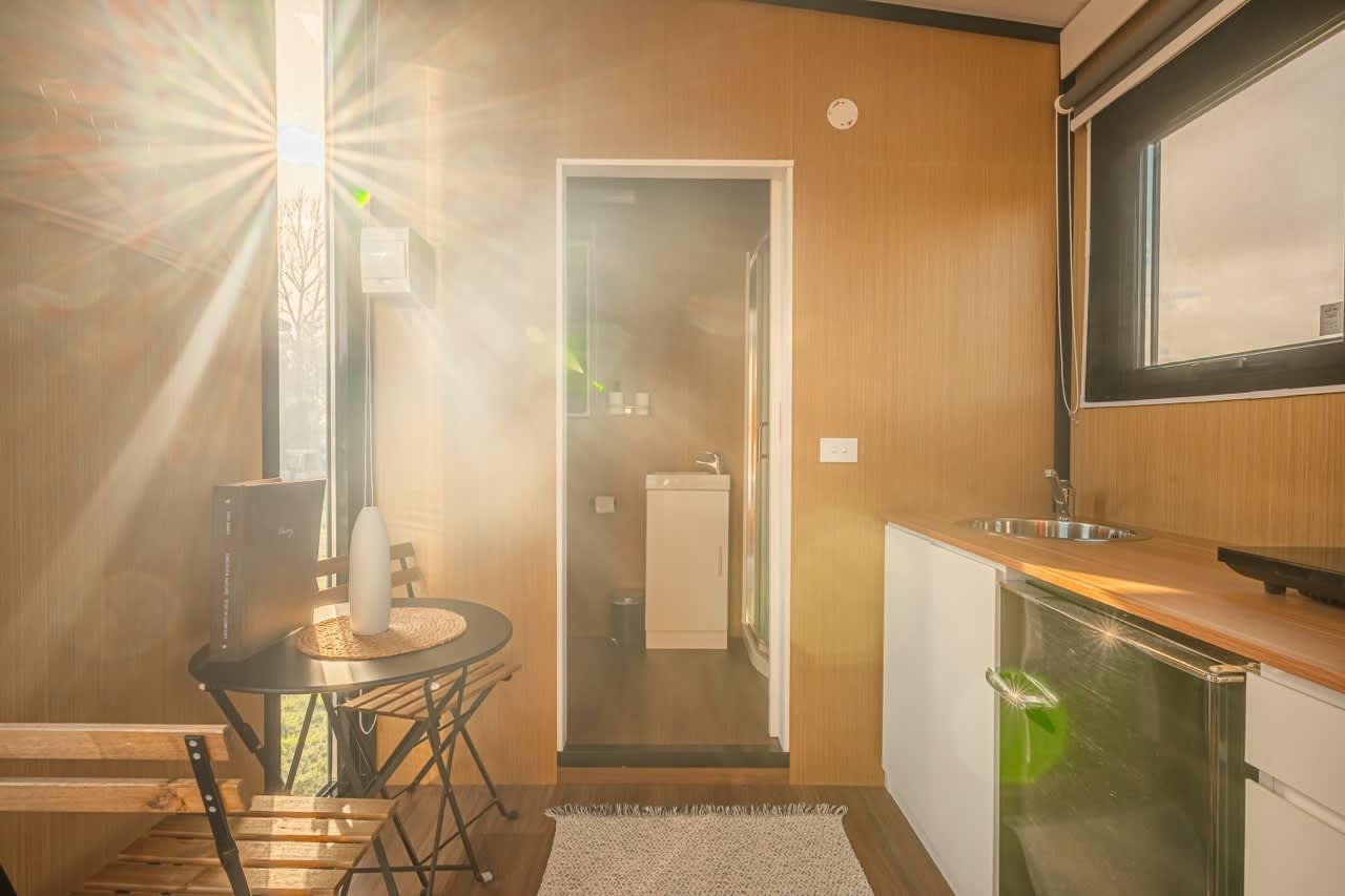 A modern kitchen with a wooden countertop, a sink, and a refrigerator.