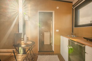Una cocina moderna con encimera de madera, un lavabo y un refrigerador.