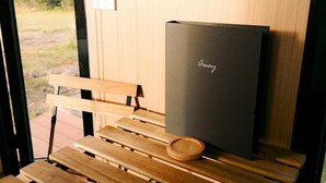 A wooden bench with a dark-colored box labeled "Away" and a wooden tray on it.