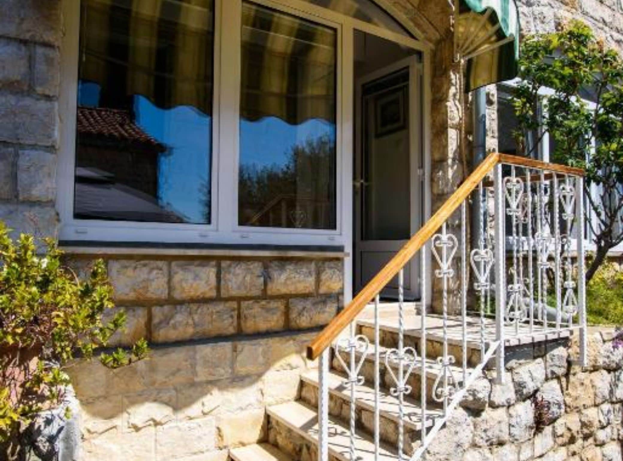 A stone building with a wooden staircase and metal railing.