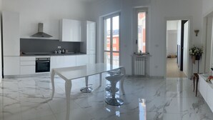 A modern kitchen with white cabinetry, a marble floor, and a large window. - B&B mare mio - the warmth of home (Pescara)