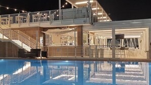 A poolside area with a bar and seating, a staircase, and a covered outdoor area.