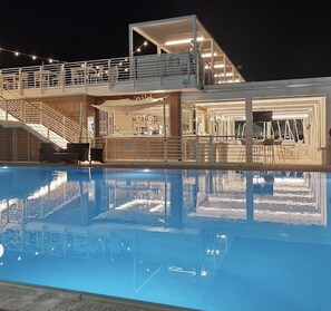 A poolside area with a bar and seating, a staircase, and a covered outdoor area. - B&B mare mio - the warmth of home (Pescara)