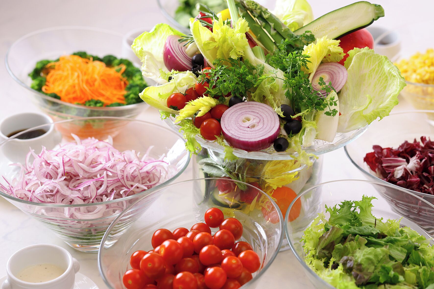 Variedad de ensaladas frescas con ingredientes como lechuga, tomates y cebollas.