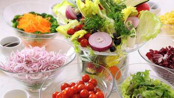Variedad de ensaladas frescas con ingredientes como lechuga, tomates y cebollas.