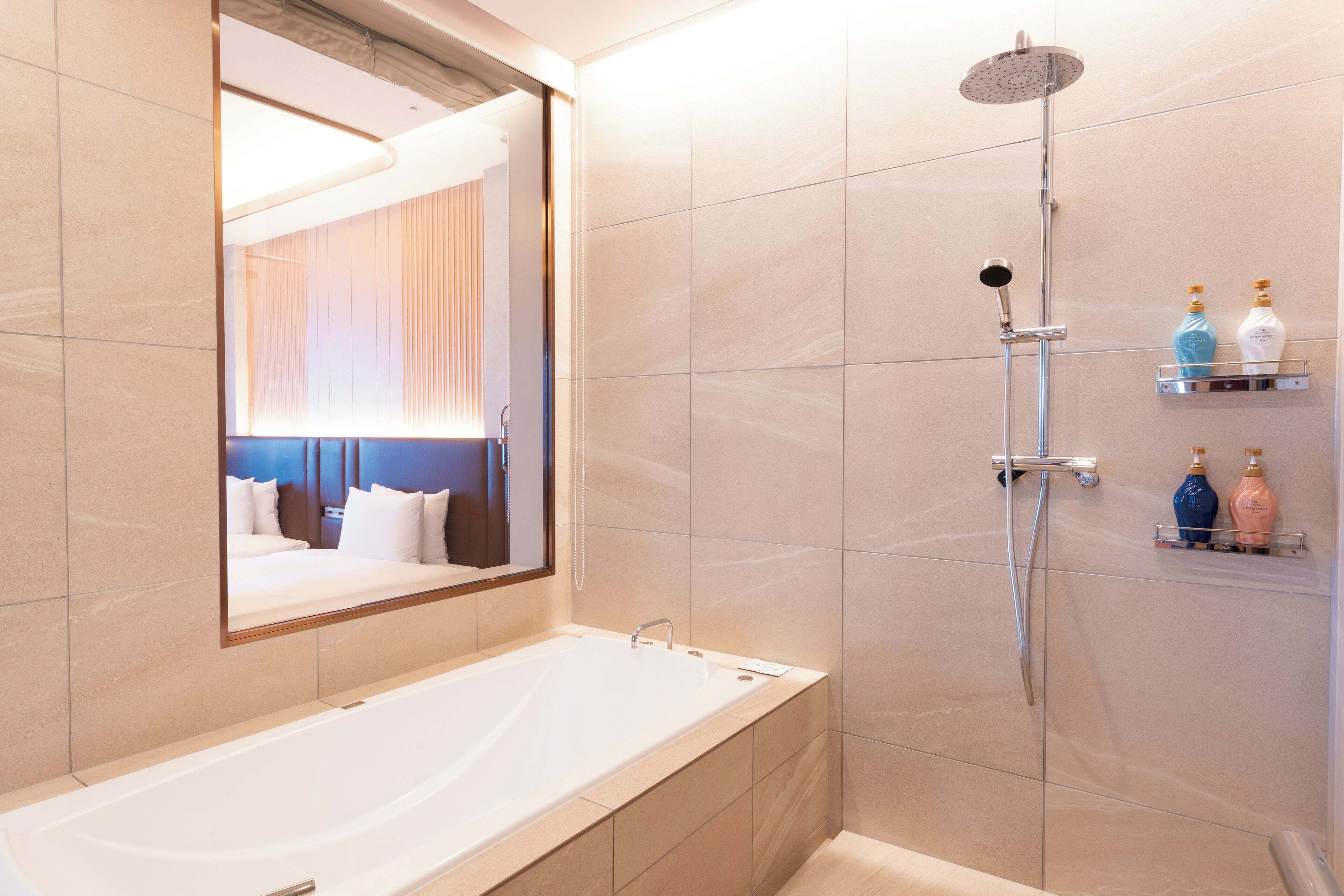 A modern bathroom with a large bathtub, a showerhead, and a mirror.