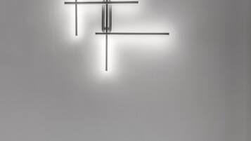 A modern living room with a sectional sofa and a minimalist wall-mounted light fixture.