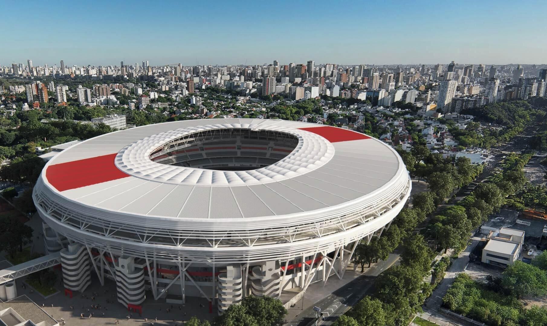A stadium with a circular design and a red roof, surrounded by a cityscape.