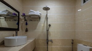 A bathroom with a white sink, a mirror, a shower, and a toilet. - Saluton Hotel (Da Nang)