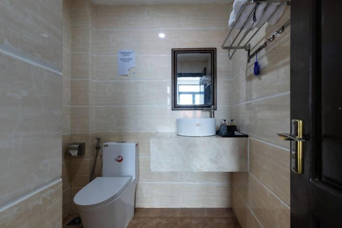A small, modern bathroom with a toilet, sink, and mirror.