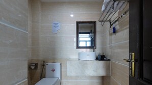 A bathroom with a toilet, sink, mirror, and towel rack. - Saluton Hotel (Da Nang)