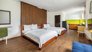 A hotel room with two wooden beds, a desk, and a kitchenette. - Saluton Hotel (Da Nang)