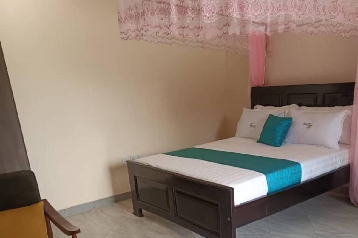 A hotel room with a bed, a chair, and a small table.