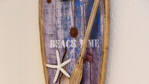 Rustikale Wanddekoration mit einem Seestern und einem Holzbrett, mit dem Aufdruck 'BEACH TIME'.