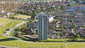 A residential area with a prominent high-rise building, a green park with a winding path, and a cemetery. - Herzlich Willkommen in der der Ferienwohnung "meerblick 9"! (Büsum)