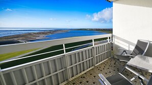 A balcony with a view of a coastal area, including a beach and a water body. - Herzlich Willkommen in der der Ferienwohnung "meerblick 9"! (Büsum)