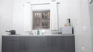 A modern kitchen with a window, a kettle, a coffee maker, and a sink. - Luxury 2 Bed Self Catering Apartment in Masvingo (Masvingo)