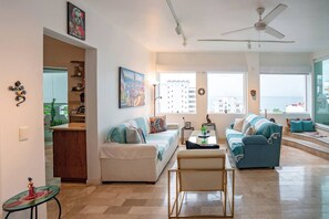 A spacious living room with a sofa, a coffee table, and a ceiling fan.