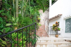 A staircase with a metal railing leading to a white door with a decorative glass panel.