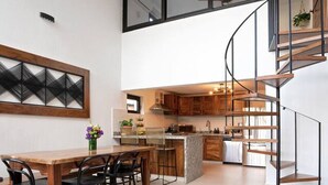 A modern kitchen with a central island, wooden cabinets, and a spiral staircase. - Beautiful Vallarta View Condo*********** (Puerto Vallarta)