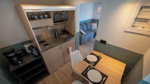 Ett litet, praktiskt kök med diskho, kaffebryggare och hyllor för förvaring.