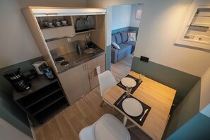 A compact kitchenette with a sink, coffee maker, and storage shelves. - Villa Vesta Retiré - Kalamata Mediterranean Suites & Villas (Kalamata)