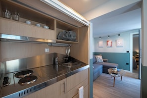Une cuisine moderne dotée d’une cuisinière intégrée, d’un évier et d’armoires en bois.