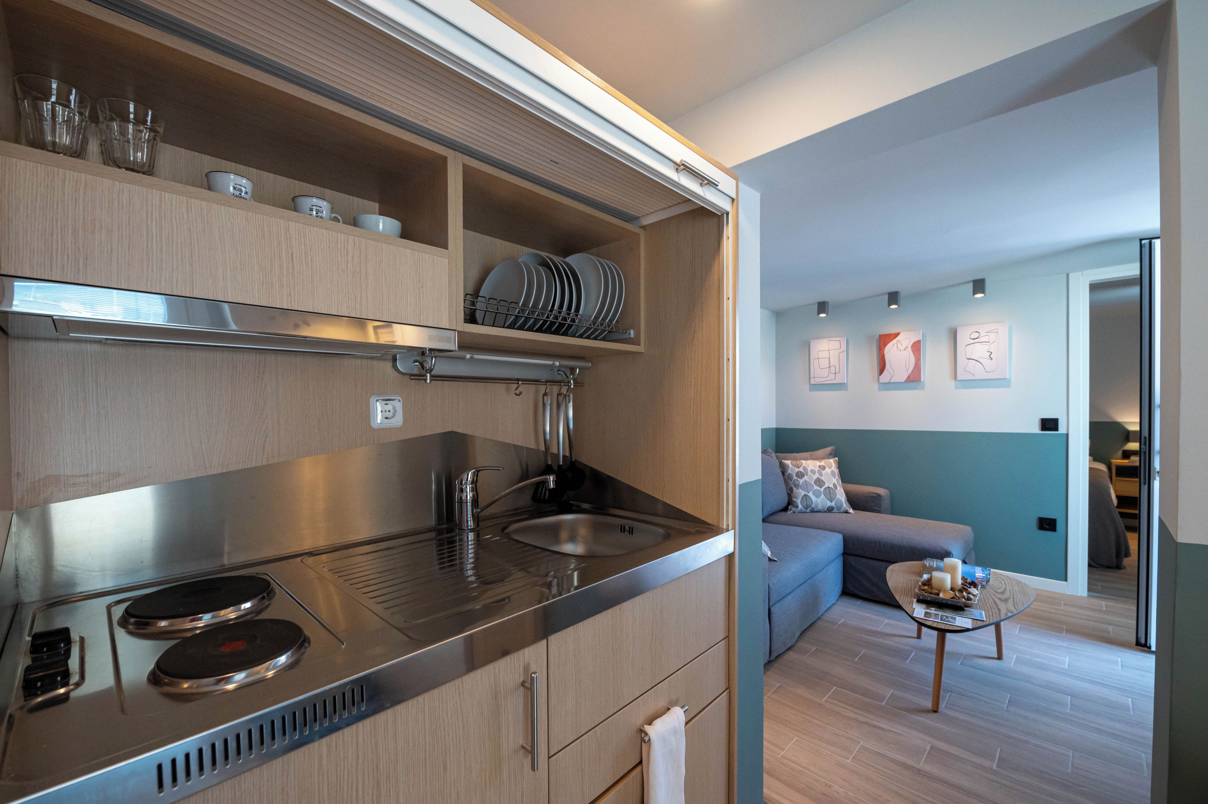 A modern kitchen with a built-in stove, a sink, and wooden cabinets.