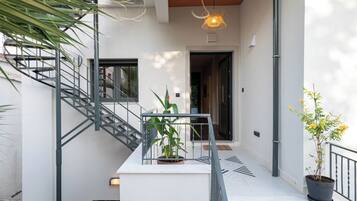 Een modern interieur met een trap, kamerplanten en een hanglamp.